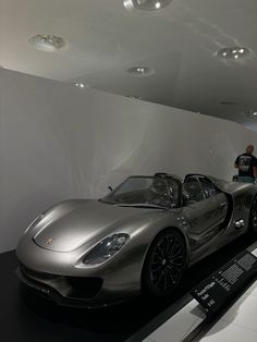 a silver sports car on display in a museum