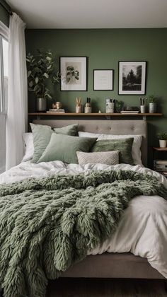 a bed with green blankets and pillows in a bedroom next to a large glass window