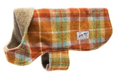 an orange and green plaid dog coat with a white tag on the back of it