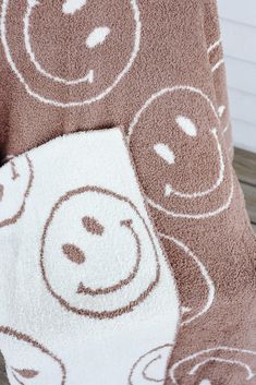 a brown and white teddy bear towel on top of a wooden floor next to a wall