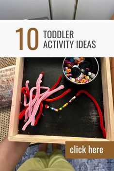 a child's hand holding a wooden tray with toys in it and the title overlay reads 10 toddler activity ideas click here