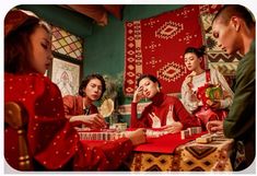 a group of people sitting around a table with boxes and presents in front of them