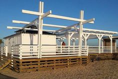 a small white building sitting on top of a sandy beach