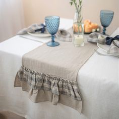 the table is set with blue glasses and plates