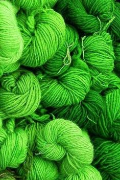 many skeins of green yarn are piled together