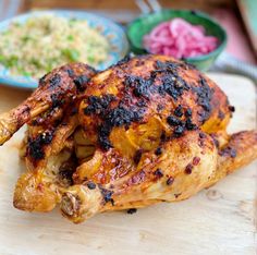 a chicken on a cutting board with other food items