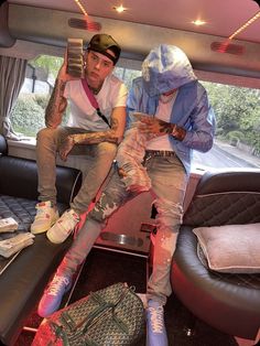 two young men sitting in the back of a car with their feet covered in paint