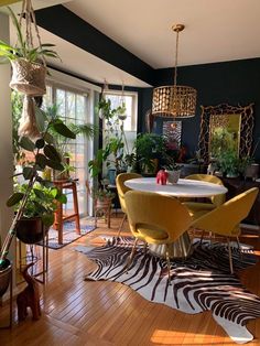 a dining room table surrounded by chairs and plants