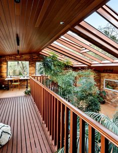 an outdoor deck with wooden railings and plants