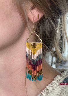 These Triangle Fringe Beaded Earrings are the perfect way to accessorize any look. Crafted from quality beads, they offer a lightweight and comfortable fit. With a unique triangle shape and detailed dangling fringe, you can make a stylish statement. Length: 3.75" Color: gold, mustard yellow, pink, silver, burgundy, terracotta and teal Triangle Beaded Earrings, Fringe Earring Pattern, Fringe Beaded Earrings, Fringe Earring, Earring Patterns, Triangle Shape, Fringe Earrings, Jewelry Diy, Color Ideas