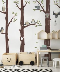 a child's room with wall decals that include owls on trees and birds hanging from the branches