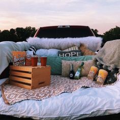 the back of a truck with pillows and other items sitting on it's bed