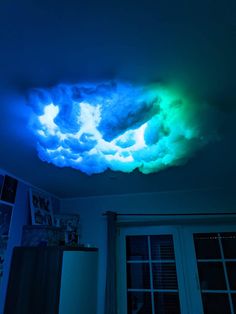 the ceiling is lit up with blue and green lights, while clouds are in the sky