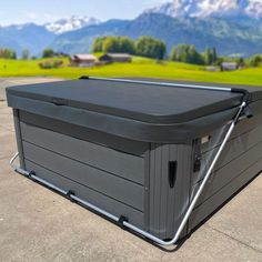 an outdoor hot tub in the middle of a parking lot with mountains in the background