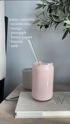 a pink smoothie in a glass with a straw