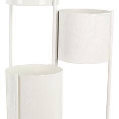 two white vases sitting next to each other on top of a stand with a lamp