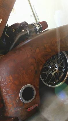 an old wooden car with chrome rims and wheels