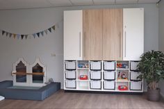 a room with several storage bins and a potted plant