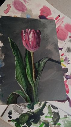 a painting of a pink tulip sitting on top of a piece of art paper