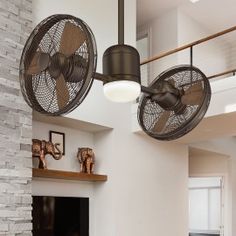 a living room filled with furniture and a fire place under a fan mounted on the wall