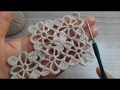 the crocheted doily is being worked on by someone using a pair of scissors