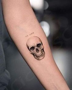 a person with a tattoo on their arm and a skull in the middle of it