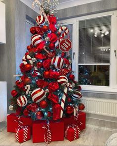 a christmas tree decorated with red and white ornaments, candy canes and candies