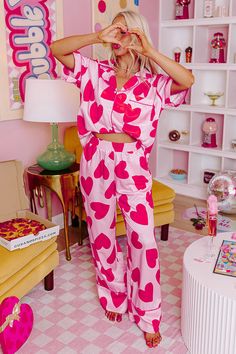 - Get your beauty sleep in these sweet pajama pants! - Unlined material with a pink heart print and accent piping - An elastic waistline - Functional side pockets - A relaxed silhouette that ends in straight hemline Pink Sleepwear With Pockets For Loungewear, Pink Heart Print Sleepwear For Pajama Party, Pink Sleepwear For Valentine's Day, Pink Sleepwear With Pockets Relaxed Fit, Pink Sleepwear With Pockets In Relaxed Fit, Pink Valentine's Day Sleepwear, Pink Relaxed Fit Sleepwear With Pockets, Pink Heart Print Bottoms For Spring, Valentine's Day Casual Sleepwear For Pajama Party