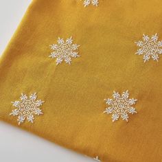 an orange fabric with white snowflakes on it