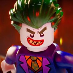 the lego batman movie character has green hair and is wearing a purple suit with red eyes