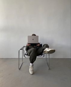 a person sitting in a chair with a laptop on their lap