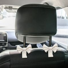 two white bows are on the dashboard of a car