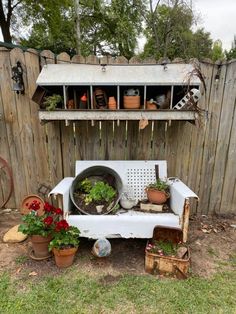 an outdoor garden area with potted plants and pots on the back of a bench