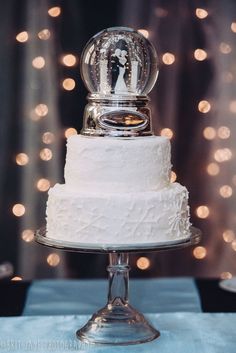 a wedding cake with a snow globe on top