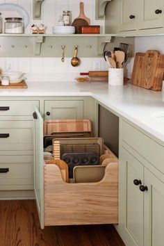 an organized kitchen with wooden utensils and cutting boards in the drawer space on the counter