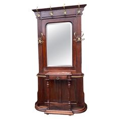 an antique wooden dressing table with mirror on it's shelf and brass fittings