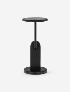 a small black table with a round top and metal base on an isolated white background