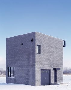 a building made out of blocks in the snow with two doors and windows on each side