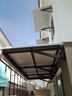 a person standing on the side of a building next to a ramp with an awning over it