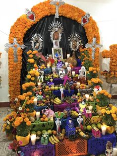 the altar is decorated with flowers, candles and other things to decorate for day of the dead