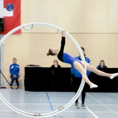 a woman is doing tricks on a hoop