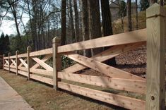 a wooden fence in front of some trees