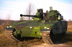 an army tank sitting on top of a grass covered field