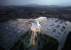 an aerial view of a parking lot with cars parked in it and the building is lit up at night