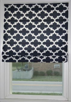 a black and white patterned roman blind in front of a window