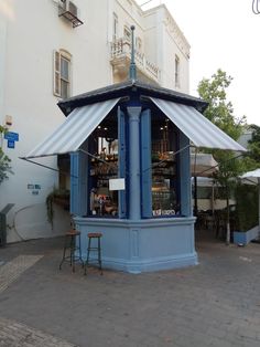 a small blue building sitting on the side of a road