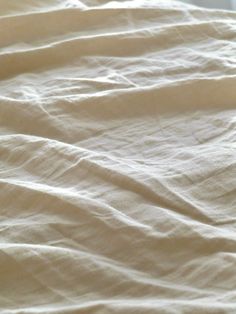 an unmade bed with white sheets on it