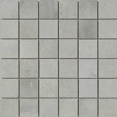 a white tile wall with squares and lines on the bottom, as well as some gray tiles