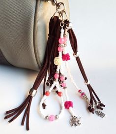 a purse with some beads and charms hanging from it