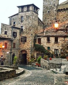 an old cobblestone street with stone buildings on both sides and a light hanging over the entrance